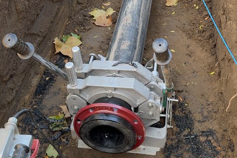 Butt fusion machine joining HDPE water main in an open trench