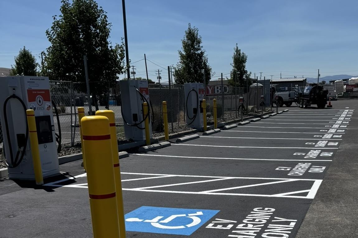 Completed EV charging stall with accessibility striping, bollards, and chargers