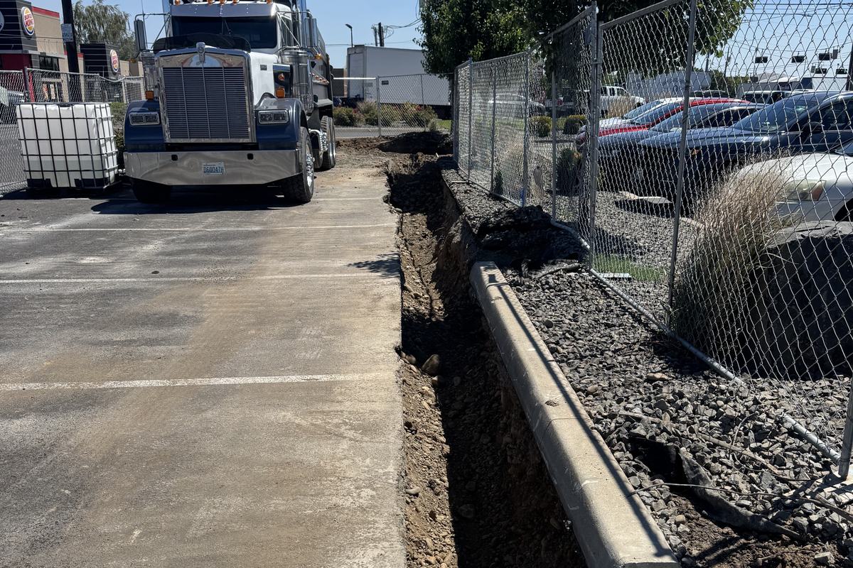 Conduit trench with gravel bedding along an existing curb
