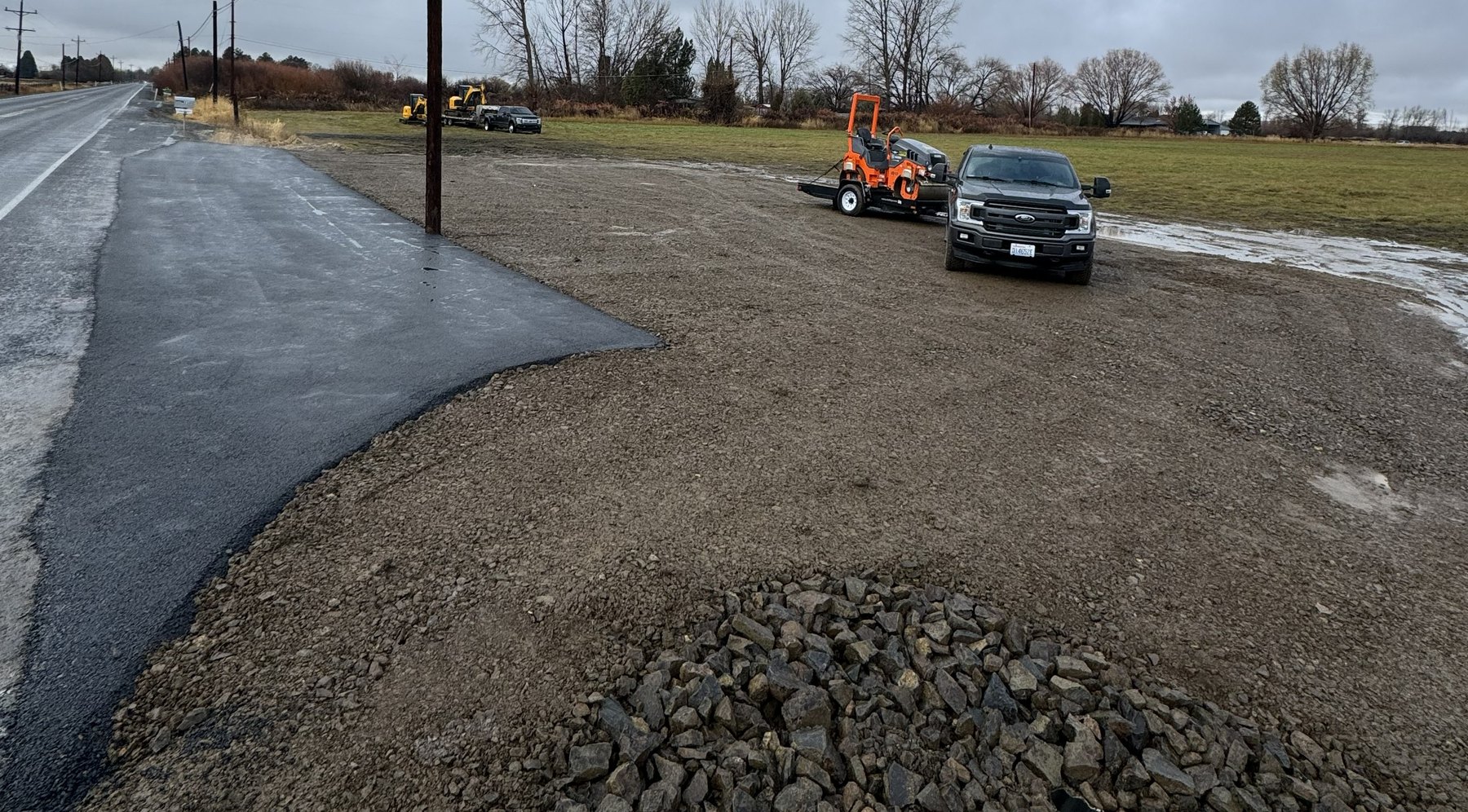 Completed Kittitas County PUD commercial approach with new asphalt, gravel shoulder, and rock armor at the culvert outlet