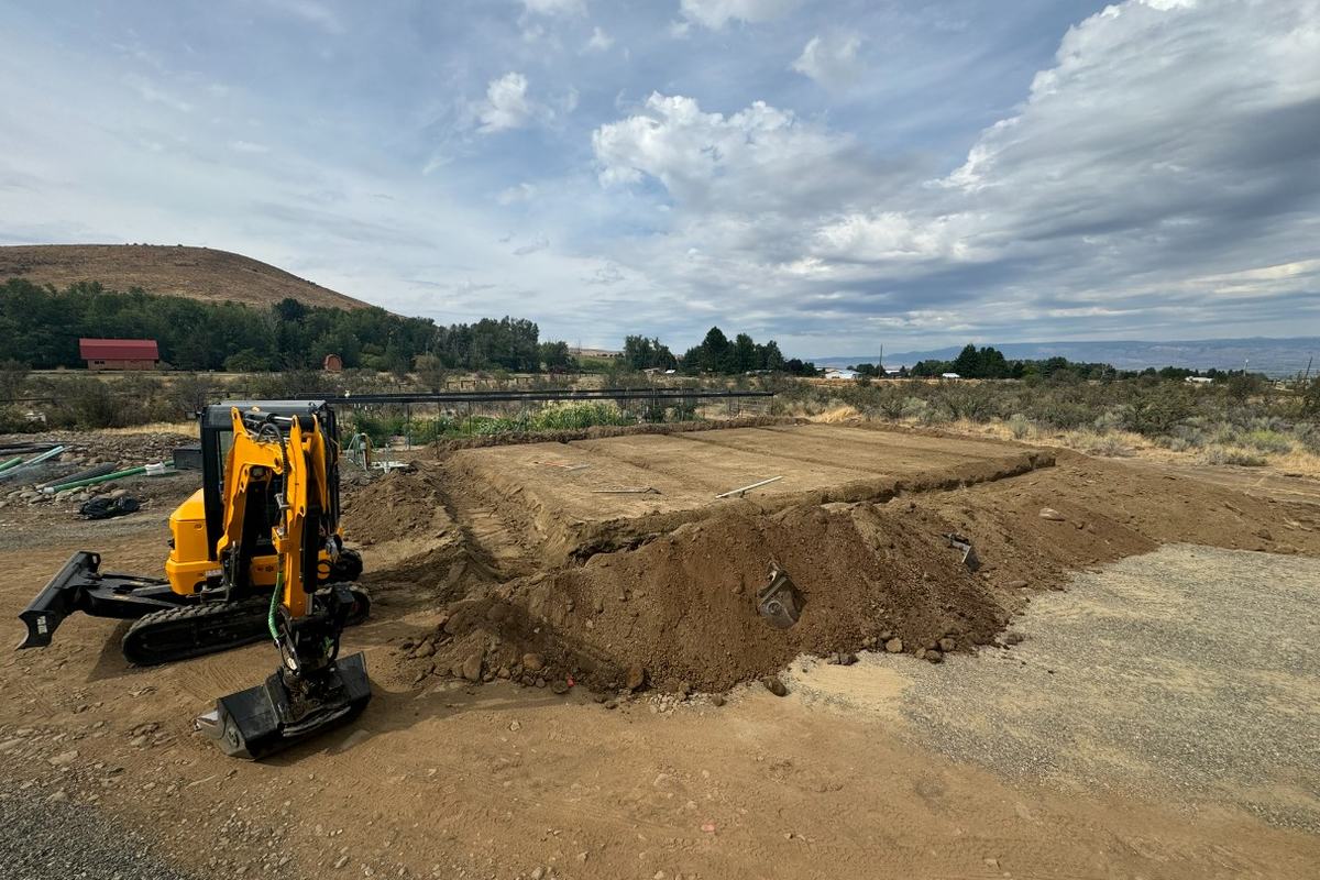 Excavator and spoil pile at a residential foundation excavation