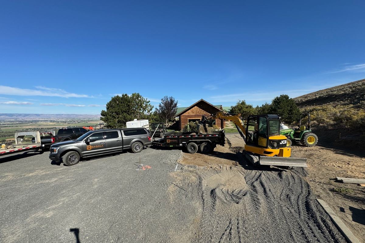Site with pickup, excavator, and aggregate stockpile