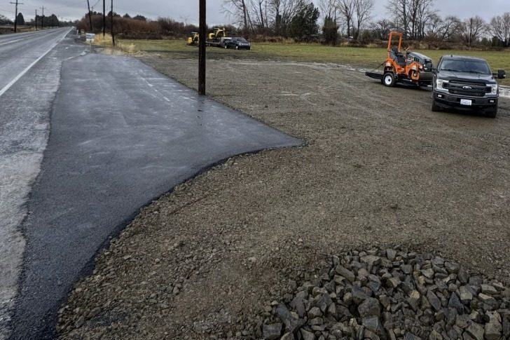 Completed asphalt approach with gravel shoulder on a county highway