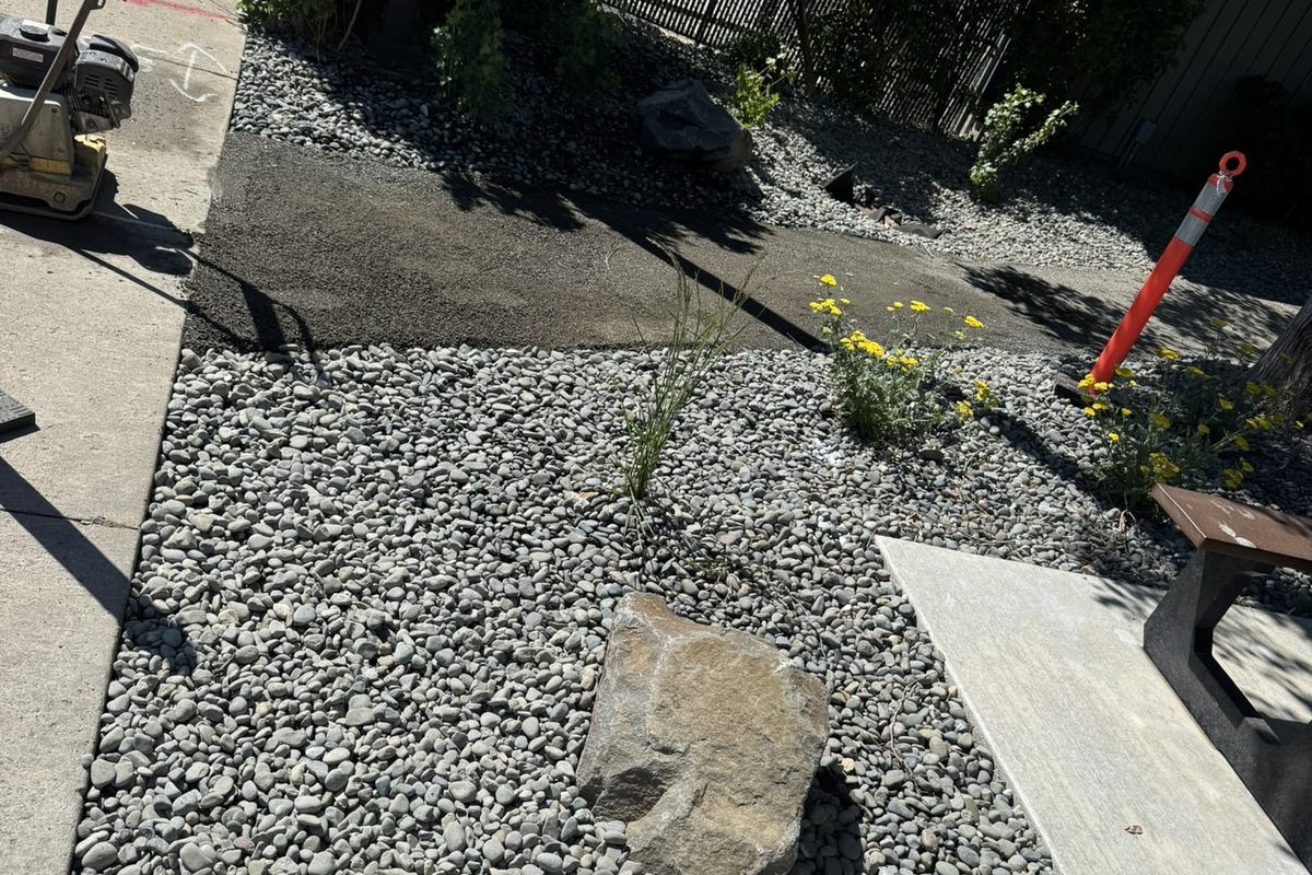 Rock and gravel restored around a new concrete walkway