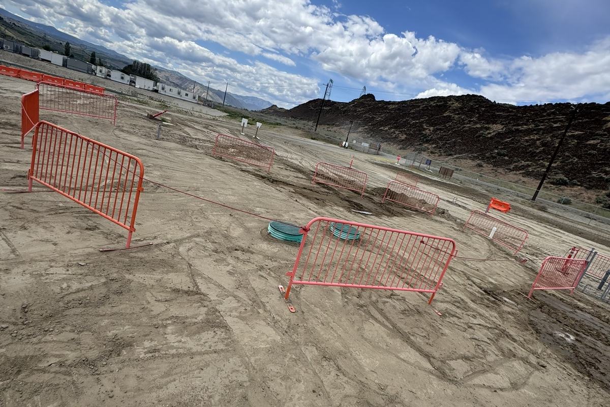 Wide graded site with safety fencing under an open sky
