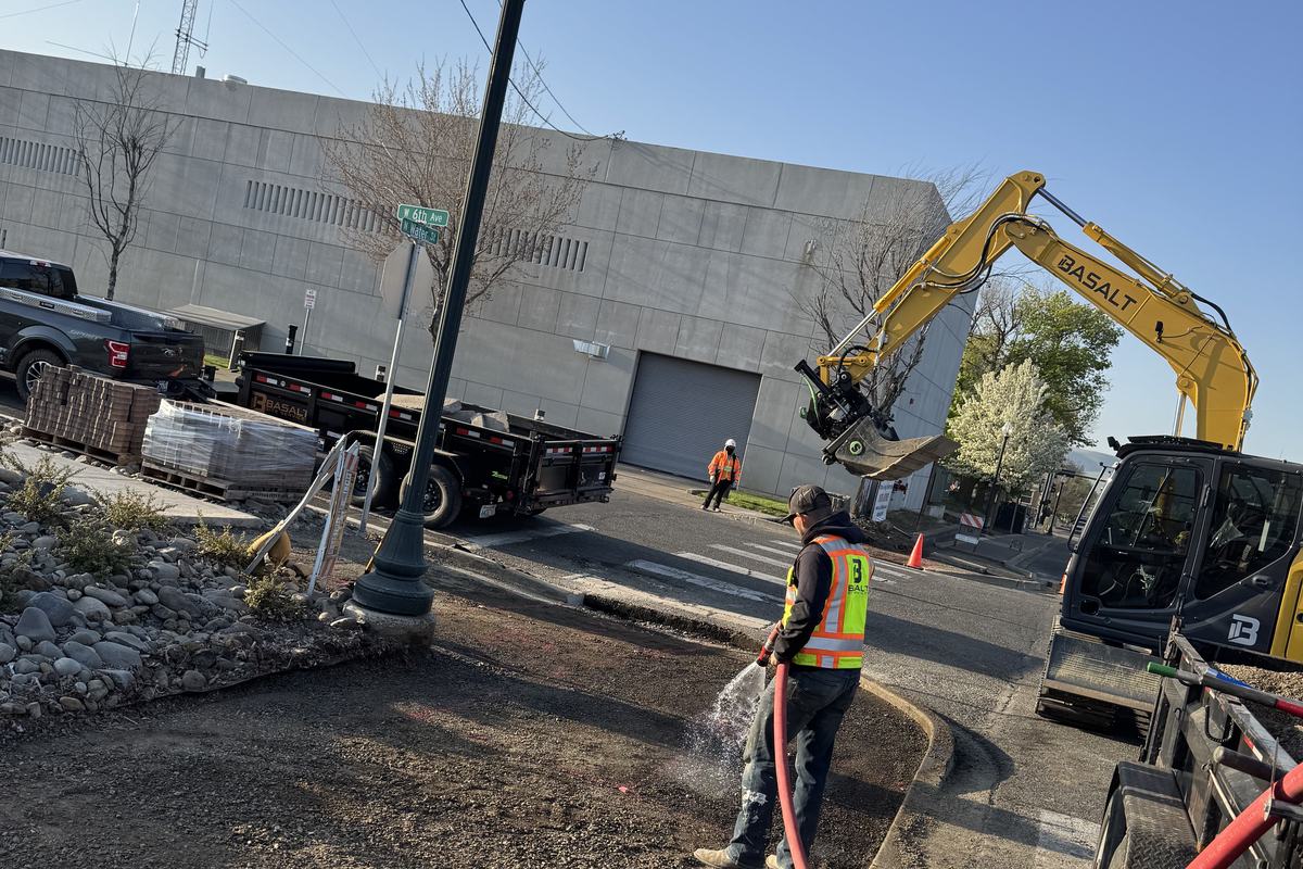 Crew and equipment working on a downtown street under traffic control